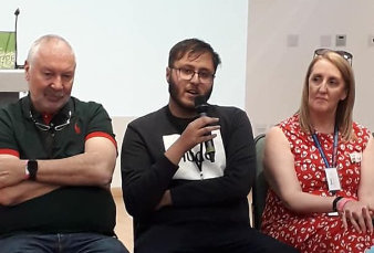 adults sat talking on a panel event